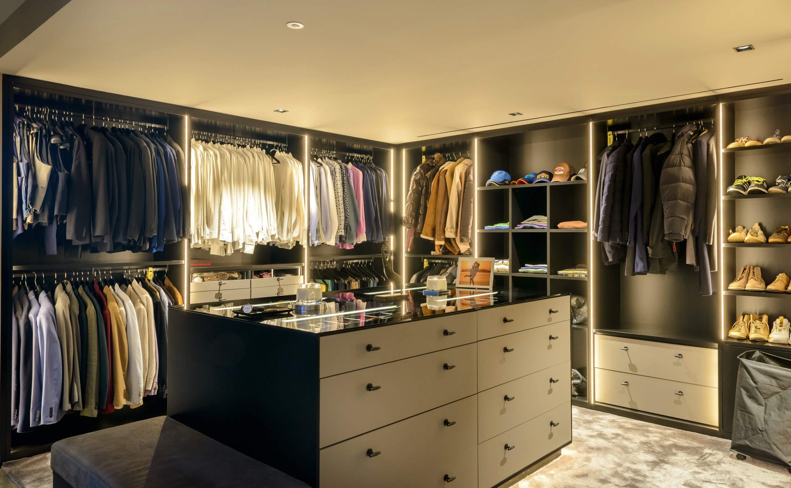 Vestidor a medida con iluminación integrada y armarios abiertos.