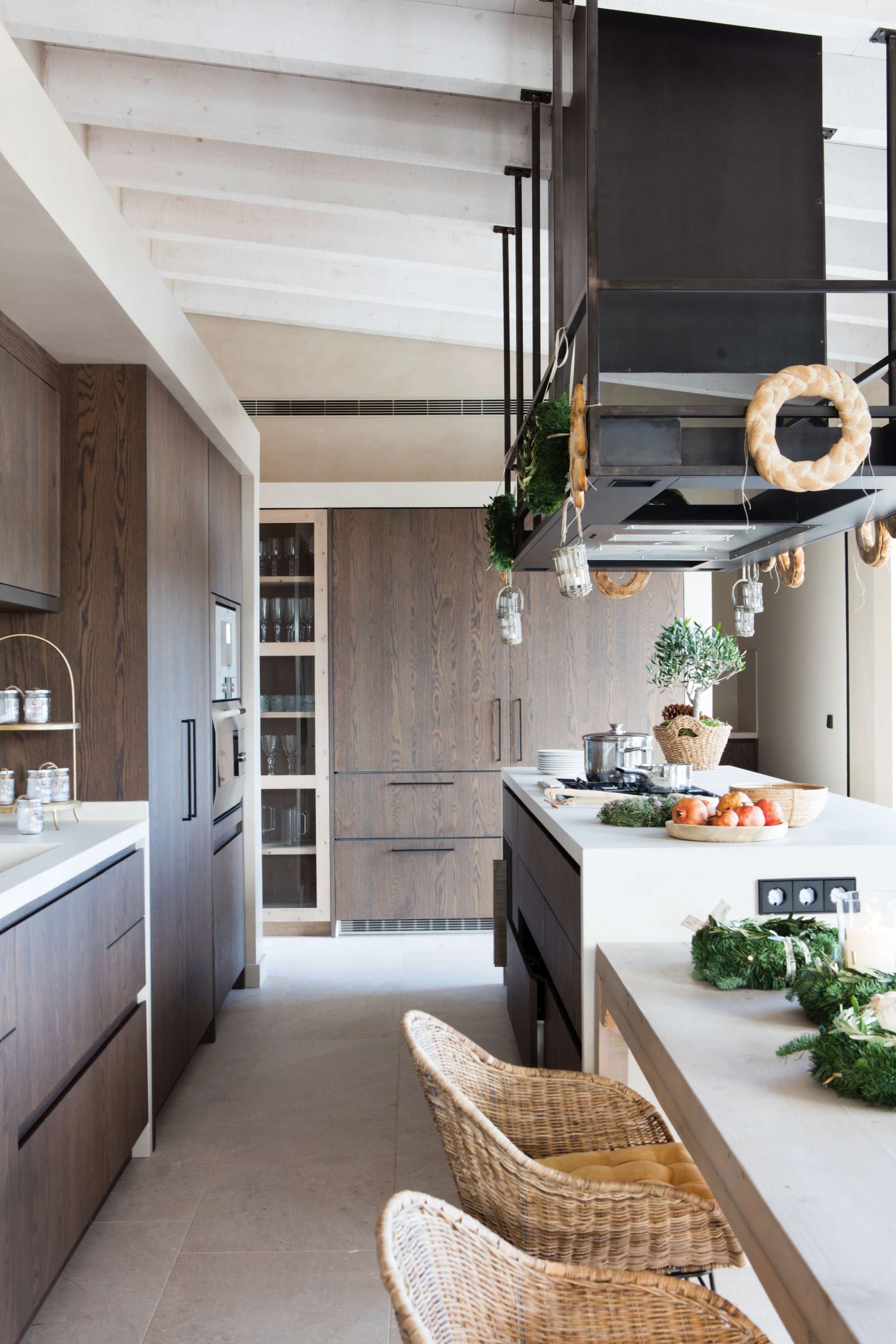 Cocina abierta con isla y acabados de madera en vivienda de diseño en Barcelona.