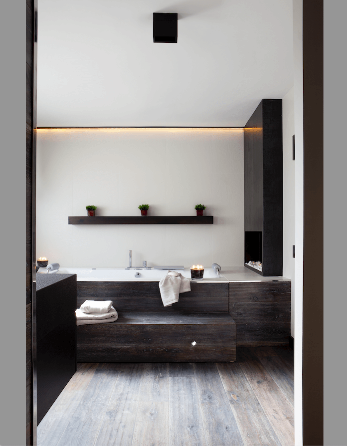 Baño minimalista con bañera y acabados en madera.