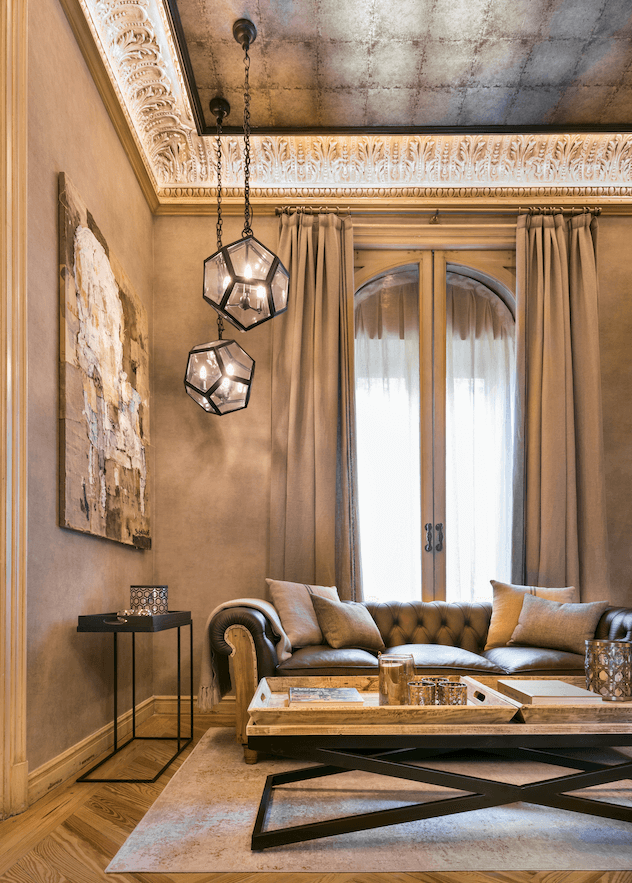 Salón elegante con sofás y lámparas colgantes.